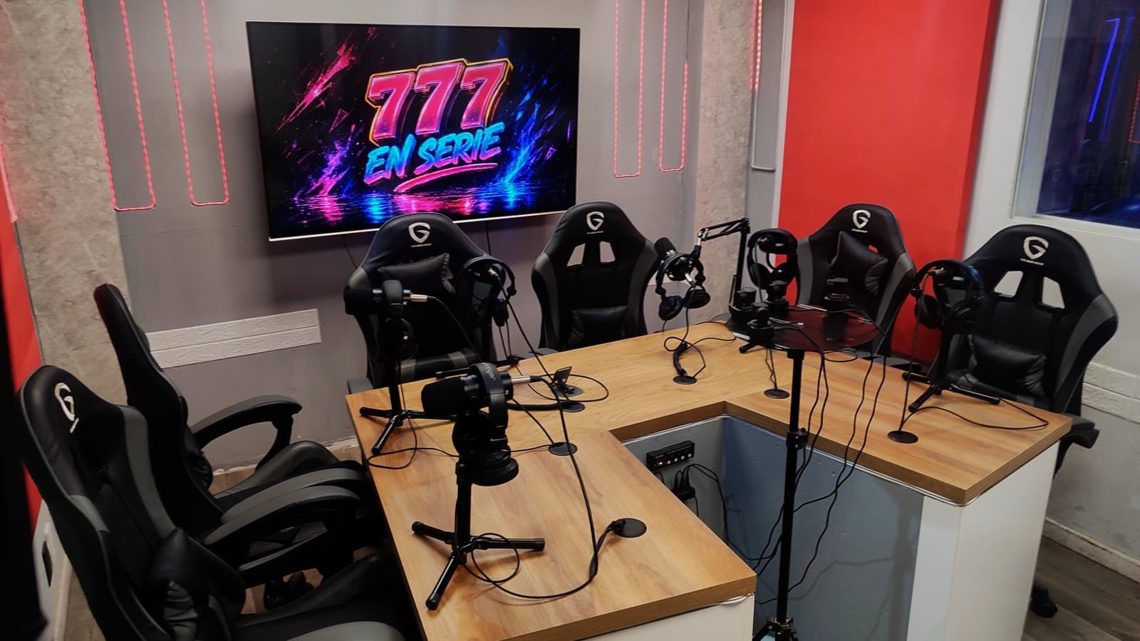 Otro ángulo de la mesa de conducción, con los brazos de micrófono y las cámaras del estudio